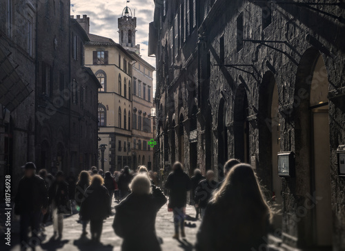 Blured crowd walking in bussy street in Siena, Italy, on dusk photo