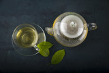 Tea cup with and tea leaf sacking on the wooden table and the tea plantations background