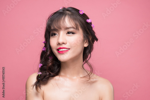 Beauty portrait of young asian woman with perfect make-up. Beautiful model girl with fresh clear skin on pink background.