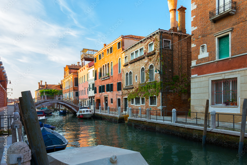 Houses along the canal in Venice, motor boats and the bridge, Italy