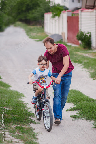father teaching his son to ride a bike