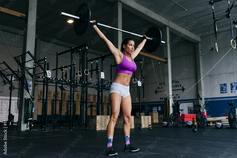 © ADDICTIVE STOCK - Determined sportswoman lifting heavy barbell