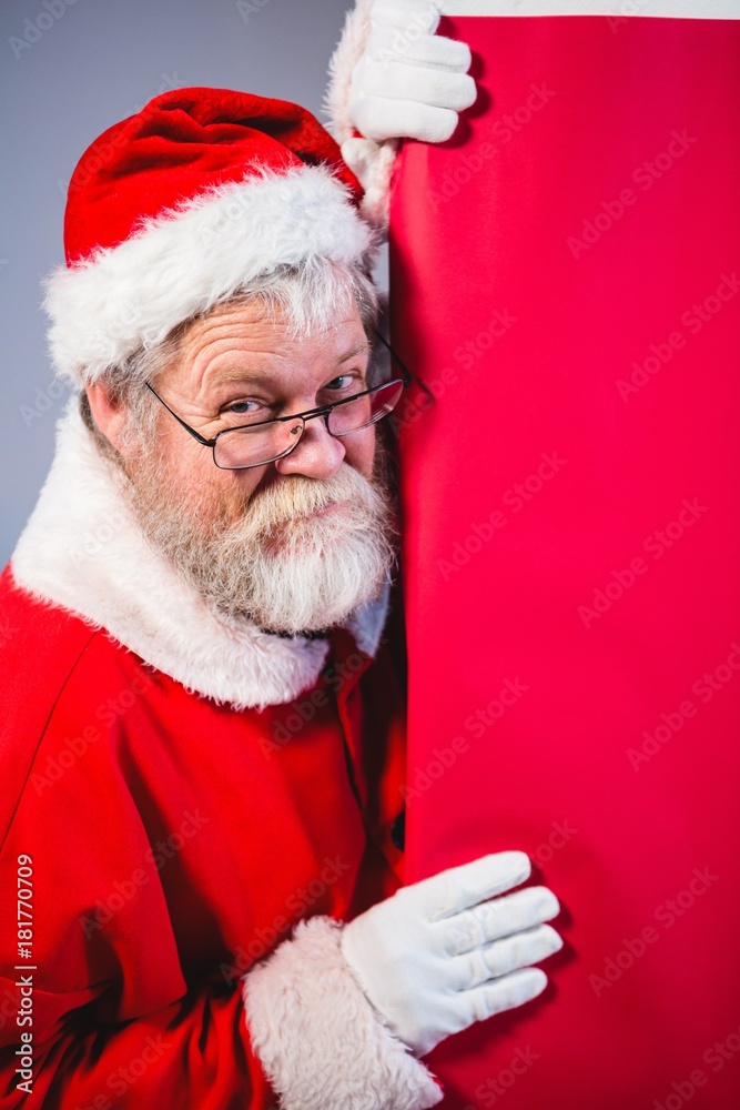 Santa Claus peeking from red board Santa Claus peeking from red board