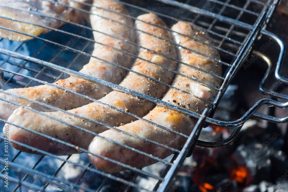 Pork sausages are fried on the grill at night, close-ups