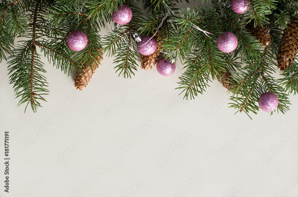 Festive fir branches decorated with fir cones and pink shiny new year balls. Christmas background.
