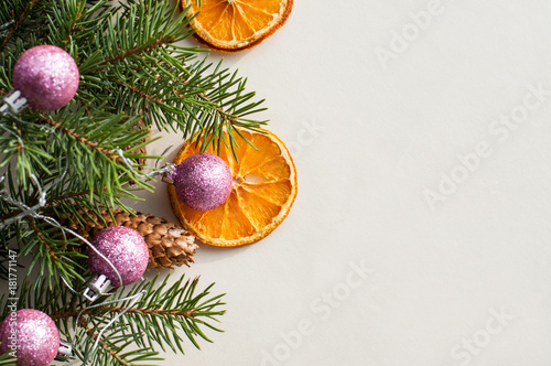  Festive fir branches decorated with fir cones, pink shiny new year balls and dried orange rings. Christmas background.