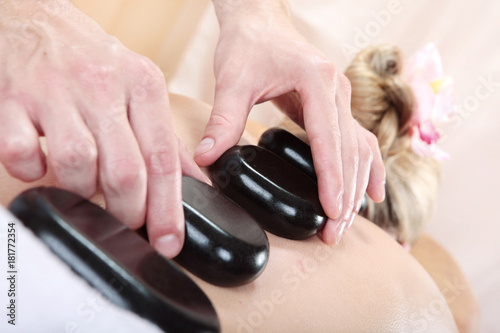 woman receiving a massage with hot stone in a spa