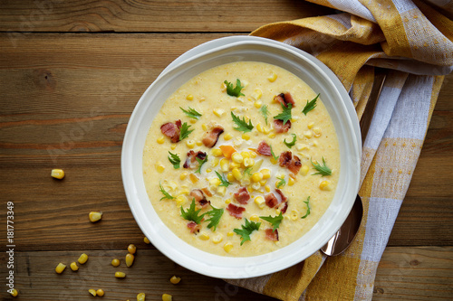 Corn chowder soup with bacon. Brown wooden background. Top view photo
