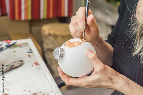 Painting of Christmas decorations, Woman paints with a brush Christmas ball photo