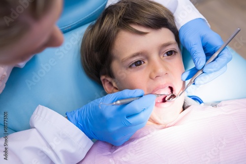 High angle view of dentist examining boy