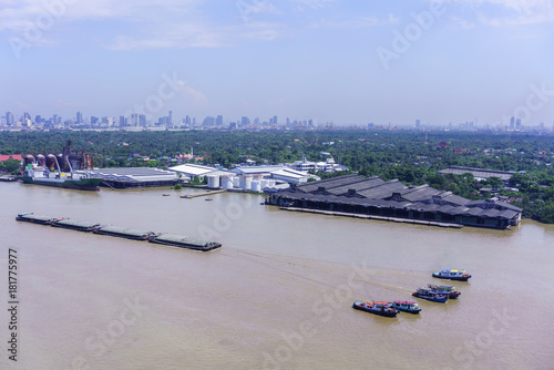 Tugboats towing sand barges along Chao Phraya river , Bangkok , Thailand