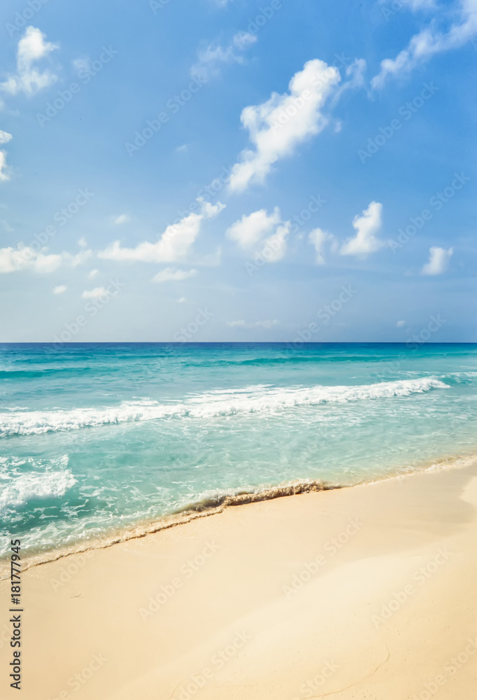 Tropical beach with golden sand and turquoise water under blue sky. Cancun, Mexico