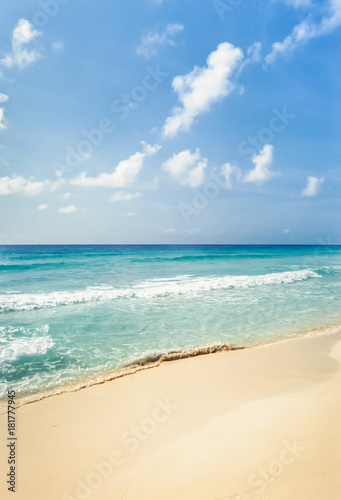 Tropical beach with golden sand and turquoise water under blue sky. Cancun, Mexico