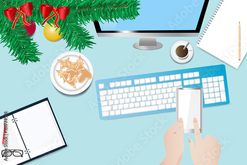 Christmas office desk with hand holding smart phone