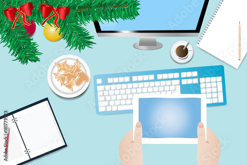 Christmas office desk with hand holding tablet