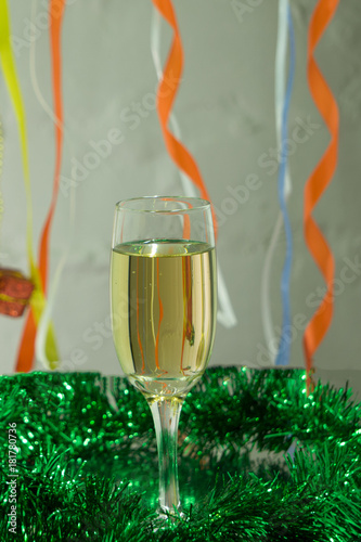 One glasses of champagne on blue tinsel for background. Xmas theme photo