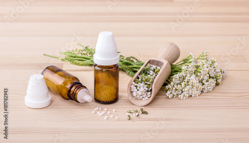 Homeopathic remedy / Homeopathic remedy with flowering yarrow and spoon with a wooden background