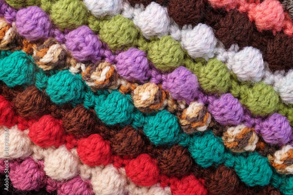 Multi-coloured crochet bobble stitches diagonal stripes background