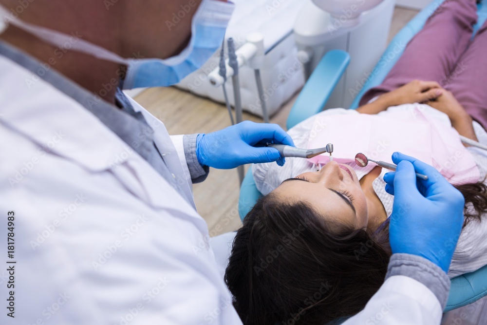 Fototapeta premium Close up of dentist examining woman mouth
