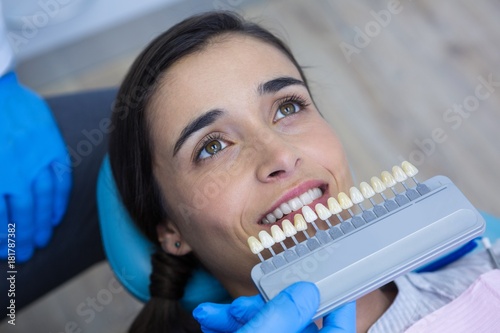 Dentist holding medical equipment while examining woman