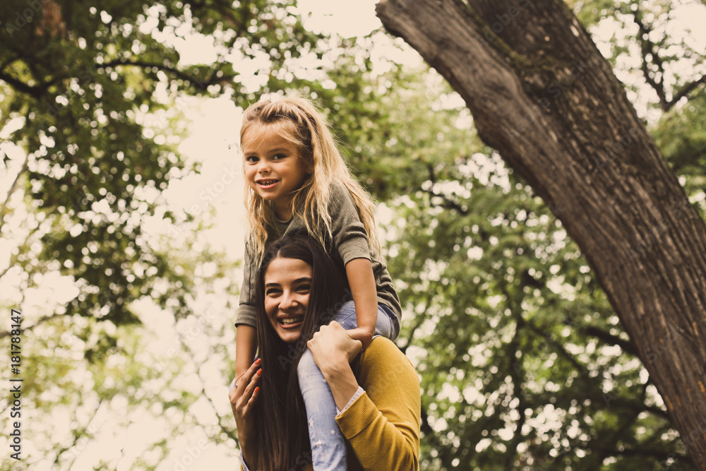 Mother carrying daughter on shoulders. Mother carrying daughter on shoulders.