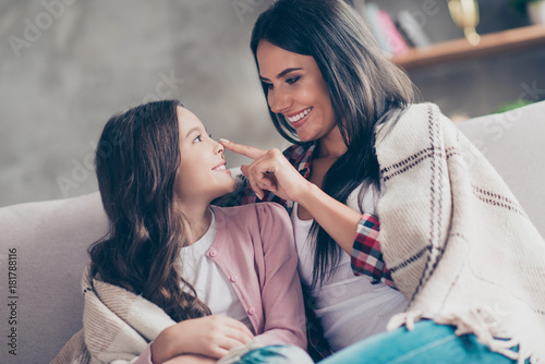 You are my biggest treasure  Cheerful tender and joyful mum with toothy smile is touching her daughter s nose  they are having fun  they have a blanket  it s cold outside