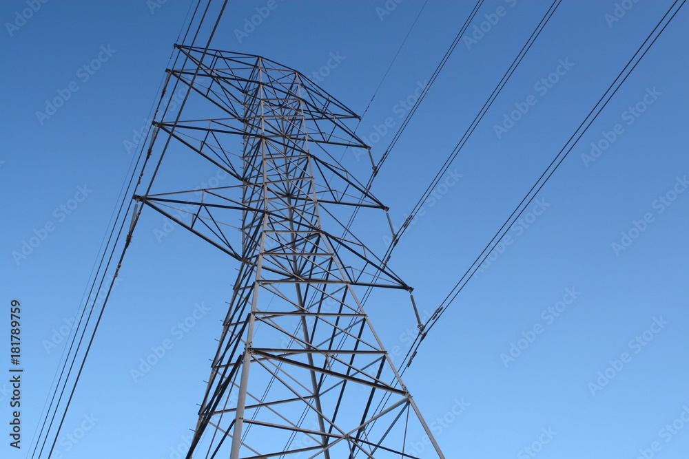 High-power electric distribution tower with a blue sky background High-power electric distribution tower with a blue sky background