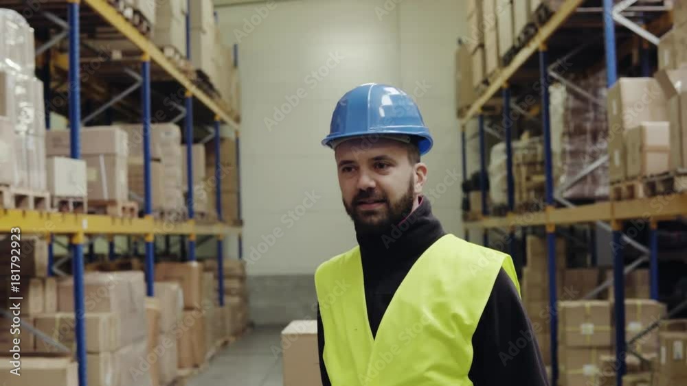 Male warehouse worker pulling a pallet truck.