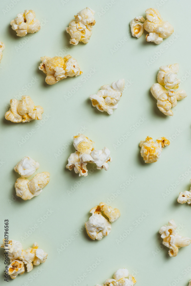 The popcorn in paper cup on green background.