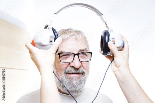 Starszy mężczyzna z słuchawkami do badania słuchu
