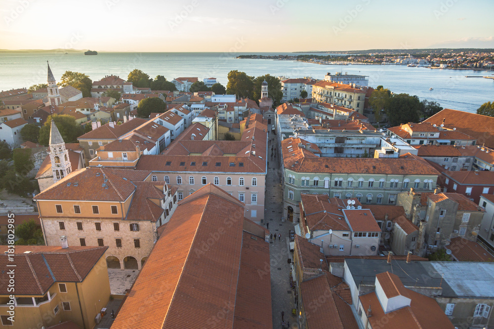 Sunset over the old mediterranean city near the seacoast of Adriatic sea. Aerial landscape of beautiful red roofs of Zadar, Croatia