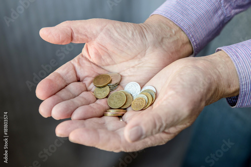 The old man stretches out his hands in which coins lie. Poverty. Russia.