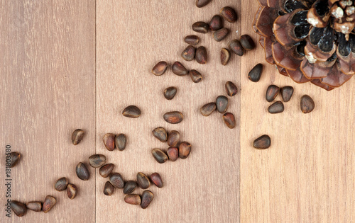 Pine nuts with cones on mahogany boards.