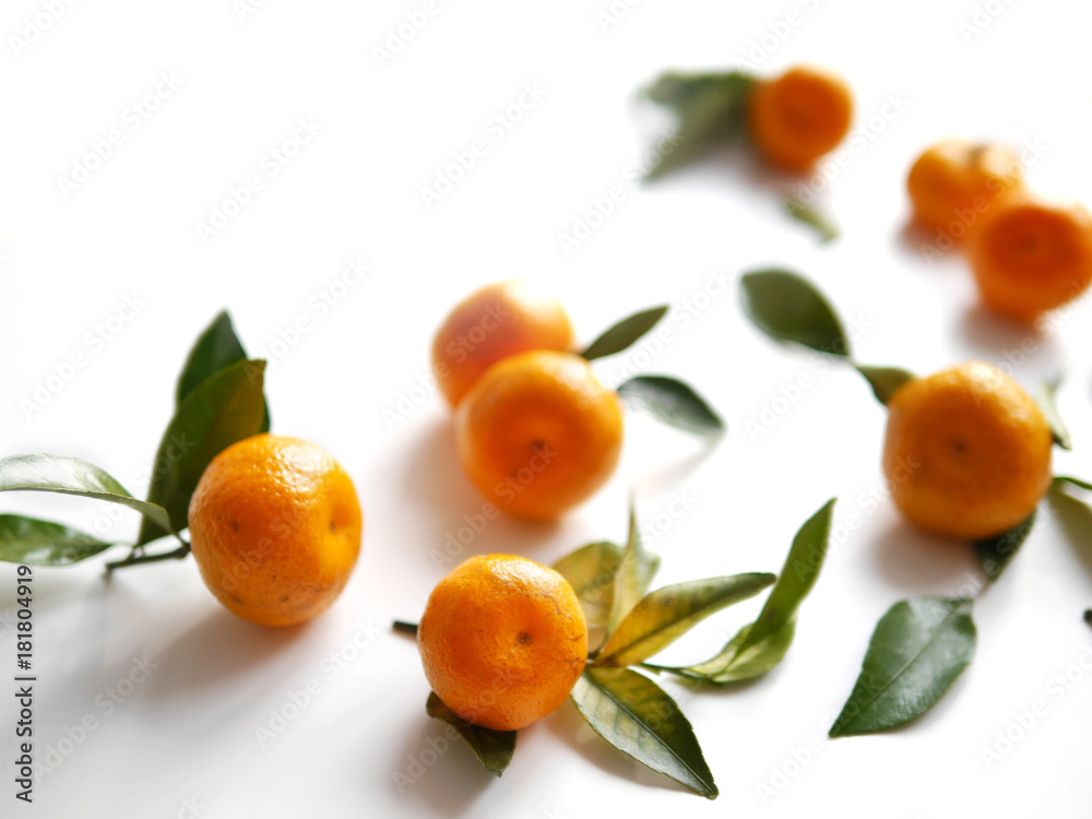 Mandarins with leaves on a white background with selective focus. Mandarins with leaves on a white background with selective focus.
