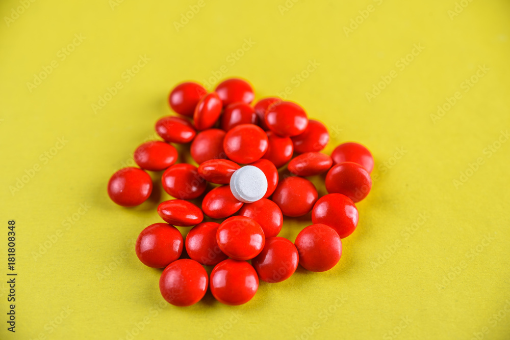 bright red pills on a yellow background. bright red pills on a yellow background.