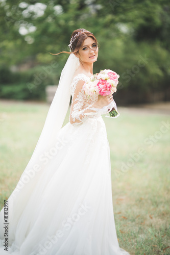 Portrait of stunning bride with long hair posing with great bouquet © olegparylyak