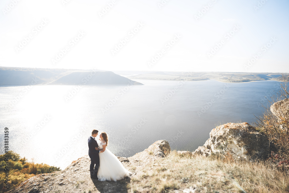 Obraz premium Happy and romantic scene of just married young wedding couple posing on beautiful beach