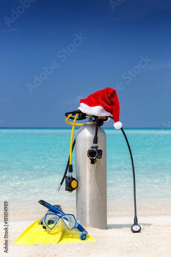 Taucherausrüstung mit Weihnachtsmütze am tropischen Strand