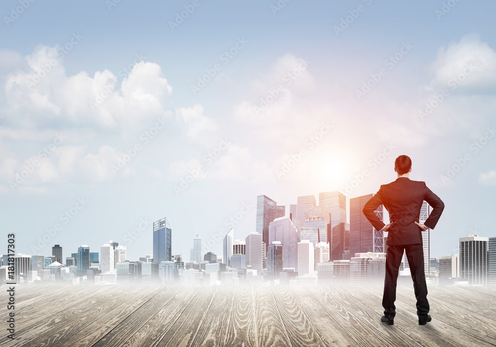 Motivation and inspiration concept with modern cityscape and businessman observing it Motivation and inspiration concept with modern cityscape and businessman observing it