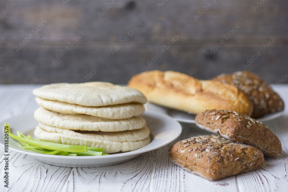 white and black bread and baguette on a wooden table white and black bread and baguette on a wooden table