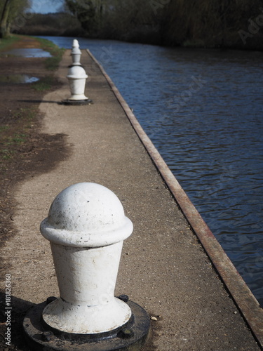 White mooring bollards perfectly in line ready for canal boats at Padworth Lock, Kennet and Avon Canal, Berkshire, UK photo