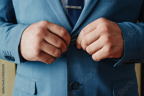 A man buttoning a blue jacket