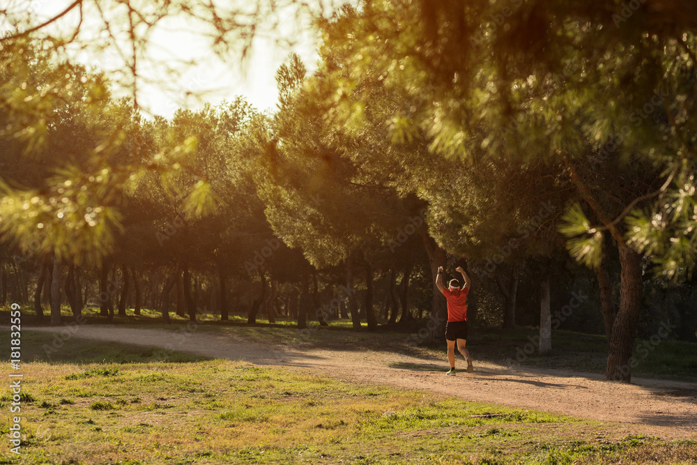 Man running in the park with his hand up