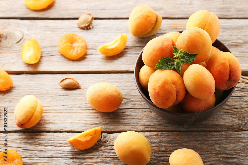 Sweet apricots in bowl on grey wooden table