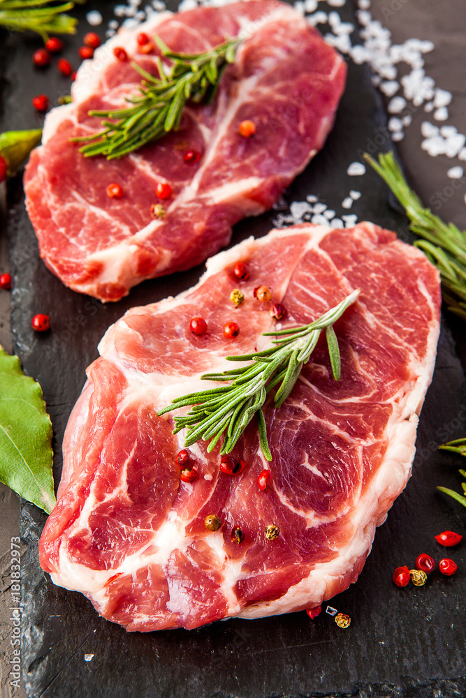 Fresh raw beef with rosemary on black background