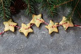 Homemade Xmas garland cookies in star shape with copy space and fir branches