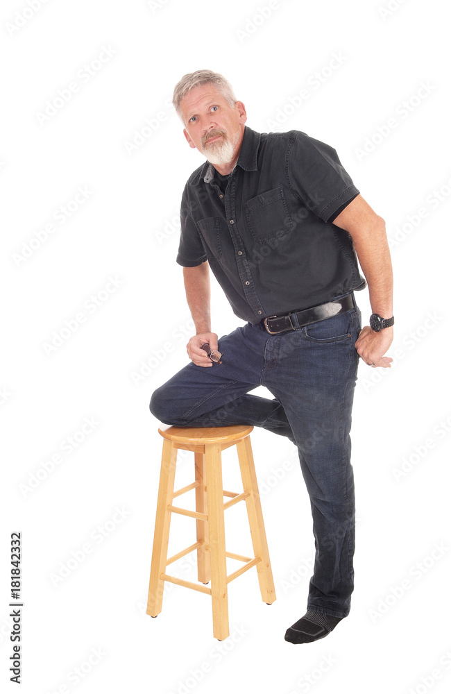 Middle aged man kneeling on chair