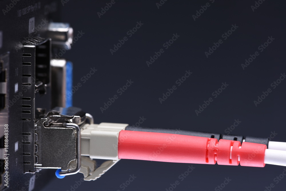 Network devices technology, optical fiber cable and switch, close-up on black background Network devices technology, optical fiber cable and switch, close-up on black background