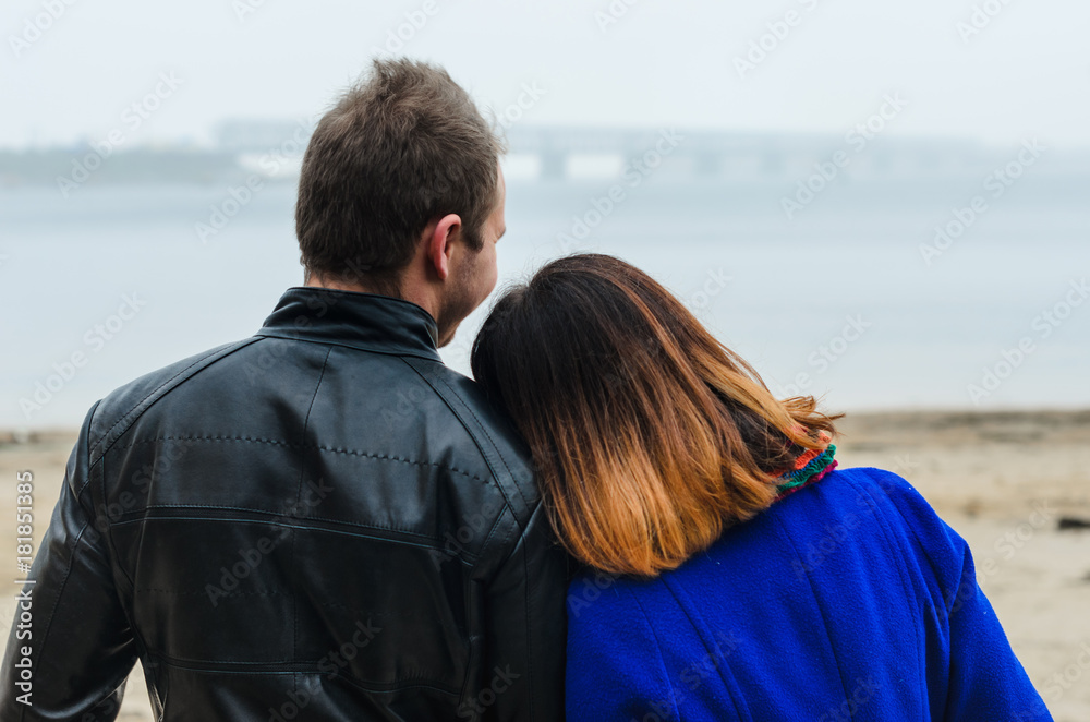the guy with the girl walking in autumn Park. deserted beach , dirty sand .stand back . the guy with the girl walking in autumn Park. deserted beach , dirty sand .stand back .