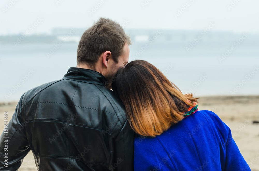 the guy with the girl walking in autumn Park. deserted beach , dirty sand .stand back .